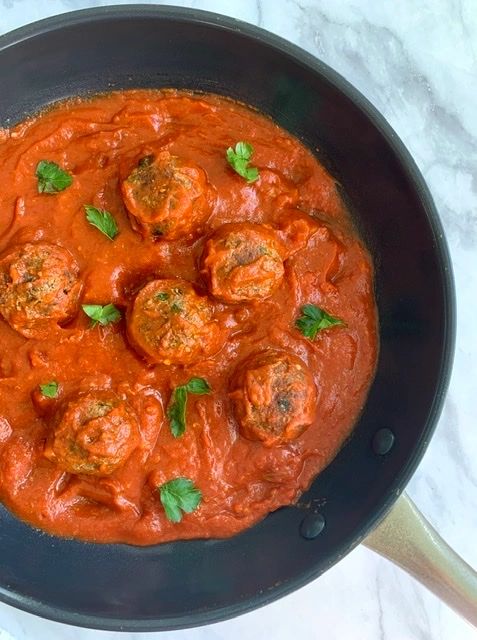 vegan meatballs and marinara sauce in a saute pan
