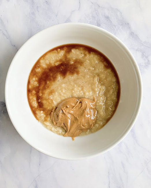 Process Image of Wet Ingredients added to a white bowl on a white marble countertop