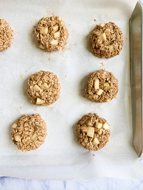 Vertical Image of Vegan breakfast cookie dough on parchment paper and metal cookie sheet.