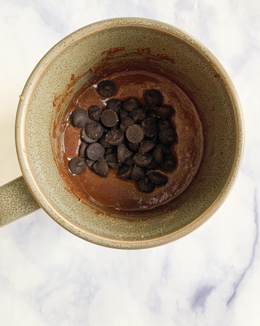 vegan fudgy butter batter in the mug with chocolate chips on top 