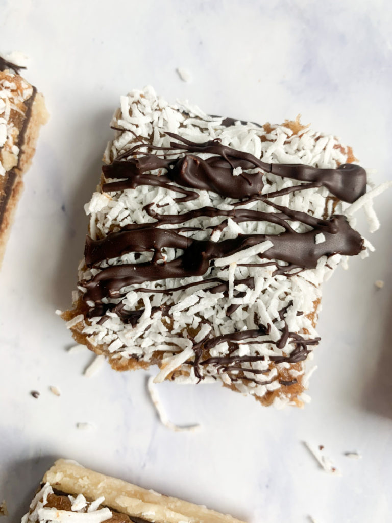 a vertical image of a healthier vegan no bake samoa bar on a white counter top 