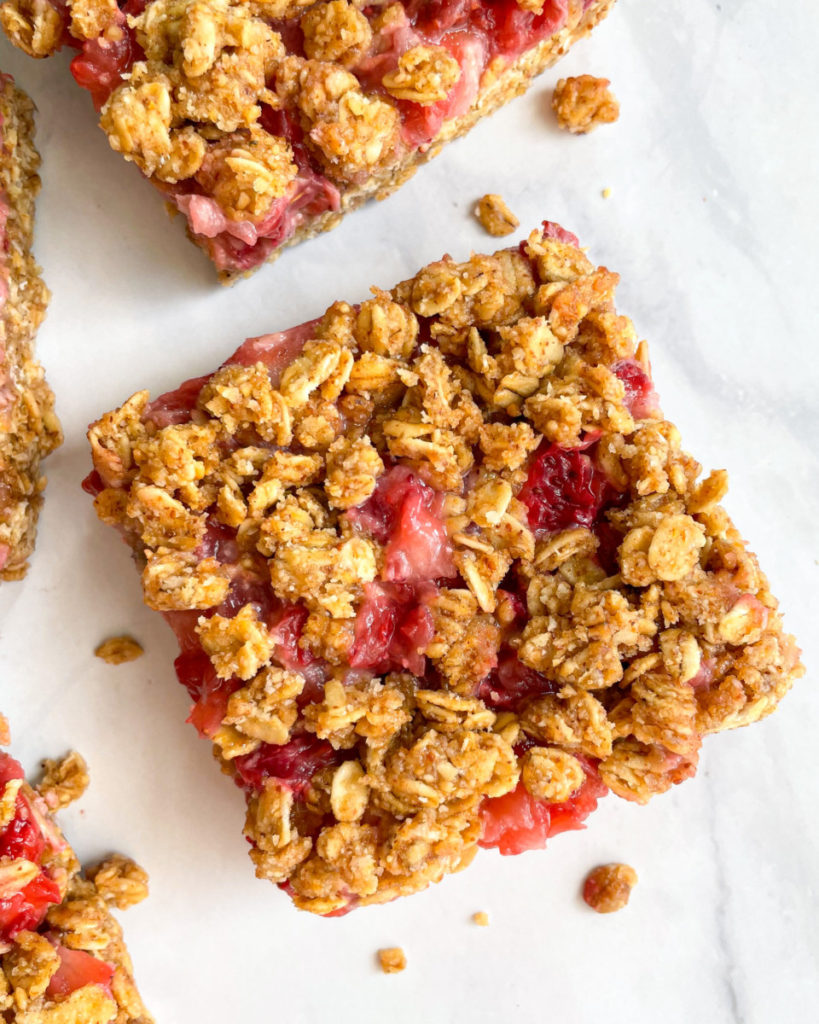 no bake vegan strawberry almond oat bars on a white counter top 