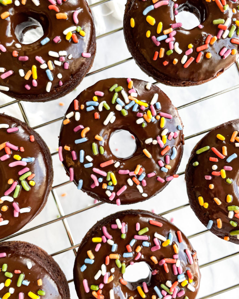 vegan oil-free chocolate donuts on a cooling rack on a white counter top 