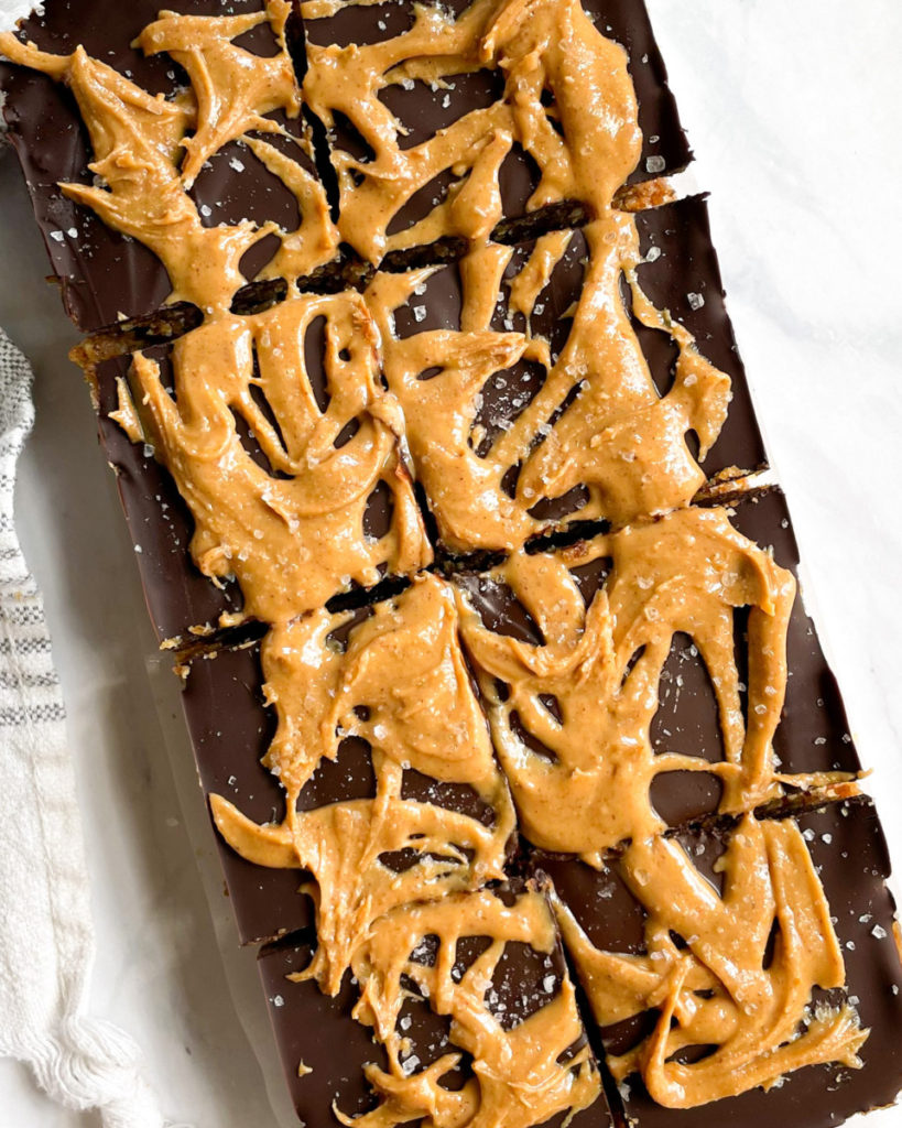 eight vegan peanut butter chocolate date bars on a white counter top 