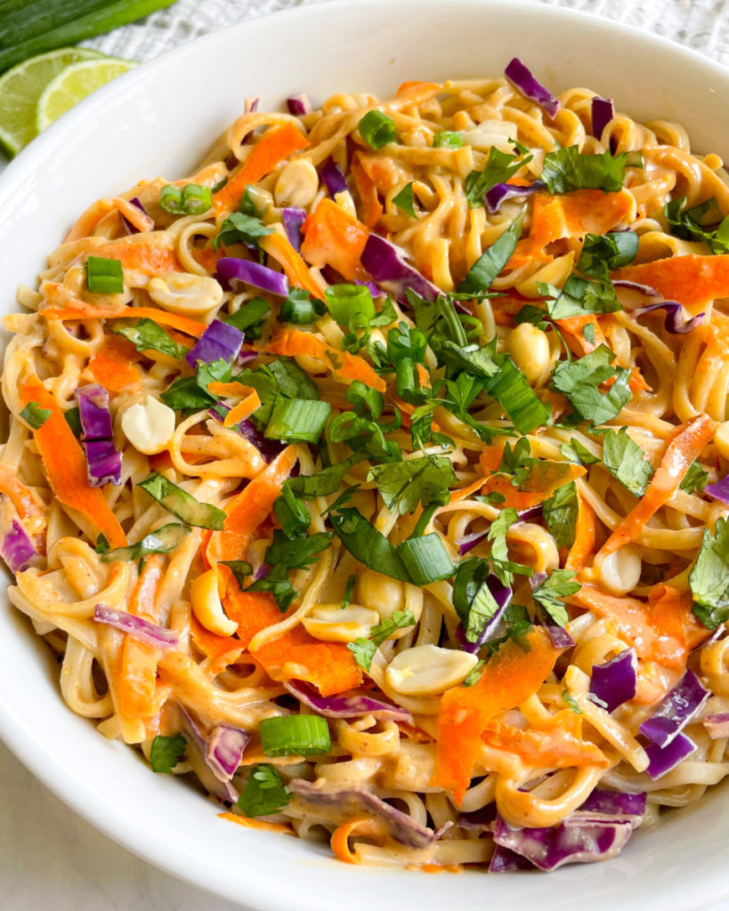 vegan oil-free peanut sauce tossed with noodles and veggies in a large white bowl